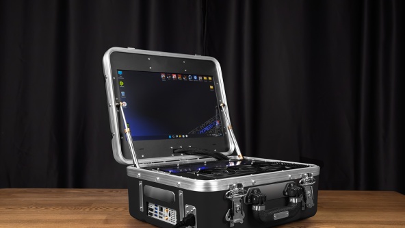 Compact computer in a suitcase with custom water cooling and built-in monitor.
