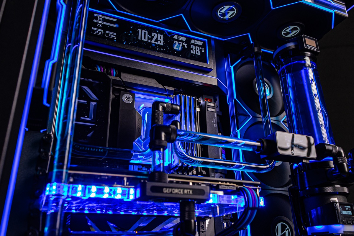 System interior: water blocks, blue coolant, and a telemetry display