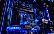 System interior: water blocks, blue coolant, and a telemetry display