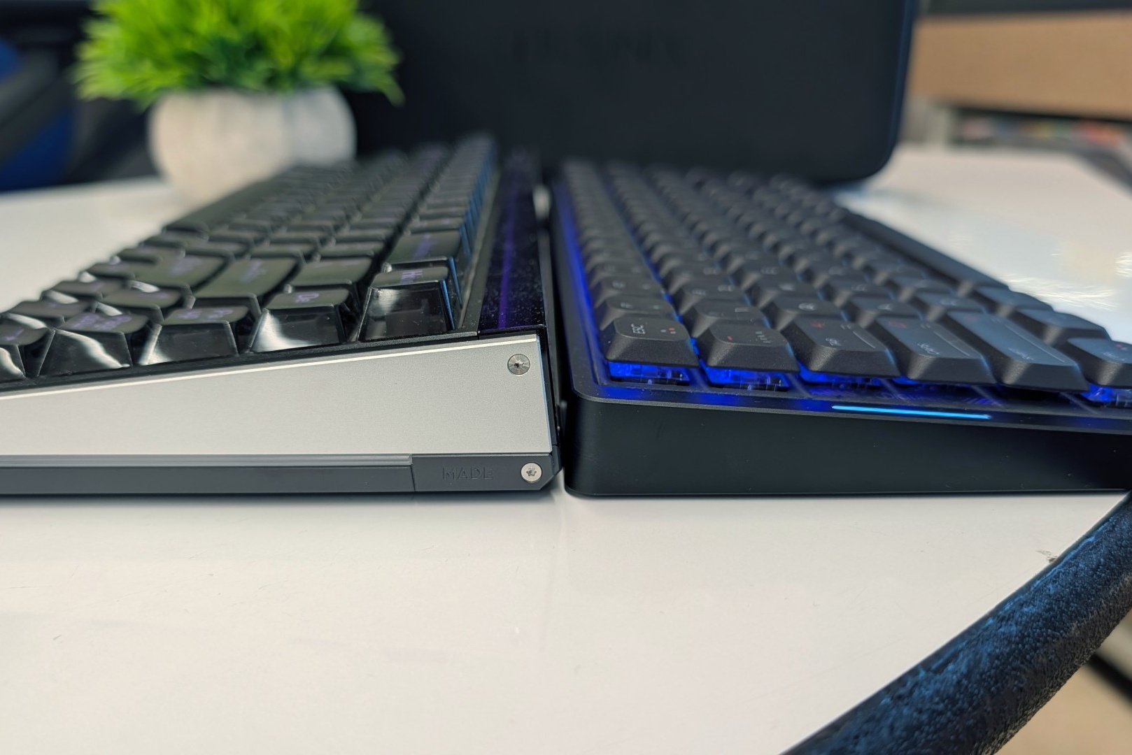 Low-profile mechanical keyboard next to a standard-height mechanical keyboard, side view